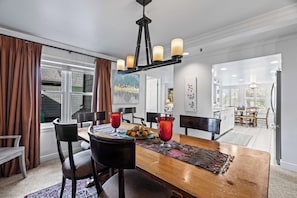 A dining area with a wooden table, chairs, and a chandelier. - Stylish condo in prime location just steps from Main Street & Town Lift Plaza (Park City)