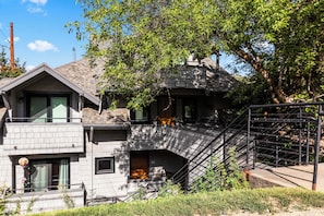 A two-story building with a stone facade, a visible staircase, and a metal fence. - Stylish condo in prime location just steps from Main Street & Town Lift Plaza (Park City)