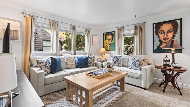 Ein Wohnzimmer mit zwei Sofas, einem Couchtisch und einer Lampe.