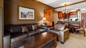 A living room with a sofa, a coffee table, a lamp, and a painting on the wall. - ski-in ski-out Condo with Shared Hot Tubs & Pool, High-Speed WiFi, and Central AC (Park City)