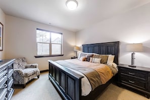 A bedroom with a large bed, a dresser, a chair, and a window. - Spacious, new-build stunner near Park City & Deer Valley with private hot tub (Kamas)