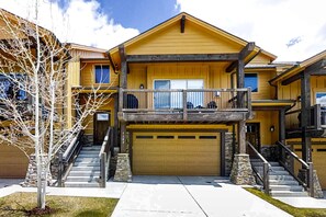 A two-story house with a balcony, a garage, and a staircase. - Spacious, new-build stunner near Park City & Deer Valley with private hot tub (Kamas)
