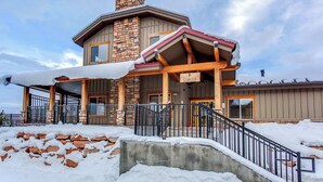 Eine Lodge mit einer Steinaußenwand, einer Veranda und einer Treppe, die zum Eingang führt.