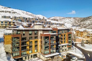 A modern multi-story hotel with balconies, located in a snowy mountainous area. - Premier Ski-in/Out Luxury Retreat w/Views & Hot Tub (Park City)