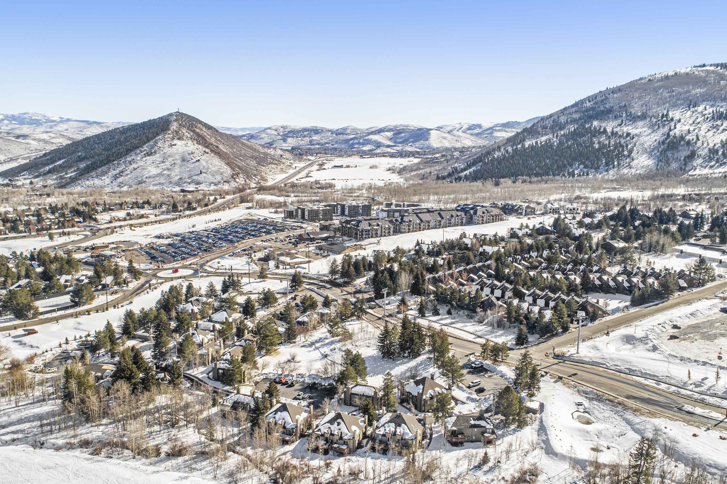 A residential area with houses, a parking lot, and a mountain backdrop.