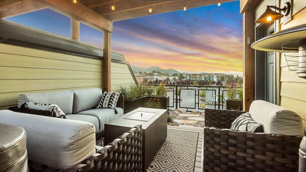 A covered patio with a sofa, a coffee table, and a wicker chair. - Private Rooftop Hot Tub Views Bumper Pool Table, High-Speed WiFi & Fireplace (Park City)