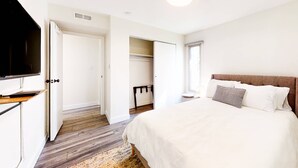 A bedroom with a bed, a television, a wardrobe, and a closet. - Modern & chic year-round getaway with mountain views & fireplace- near shopping (Park City)