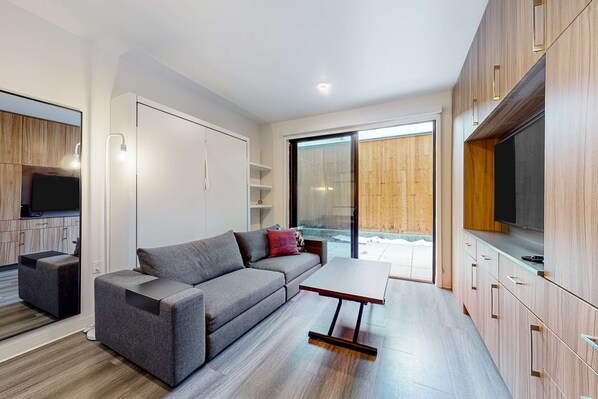 Una sala de estar moderna con un sofá, una mesa de centro y un televisor.