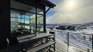 Eine moderne Außenterrasse mit Blick auf eine verschneite Landschaft.