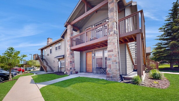 A two-story building with a balcony, stone pillars, and a covered entrance. - Redstone Center Gem - Walk to Shops, close to Ski Shuttle Stop (Park City)