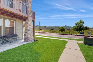A building with a balcony, outdoor seating, and a view of the landscape.