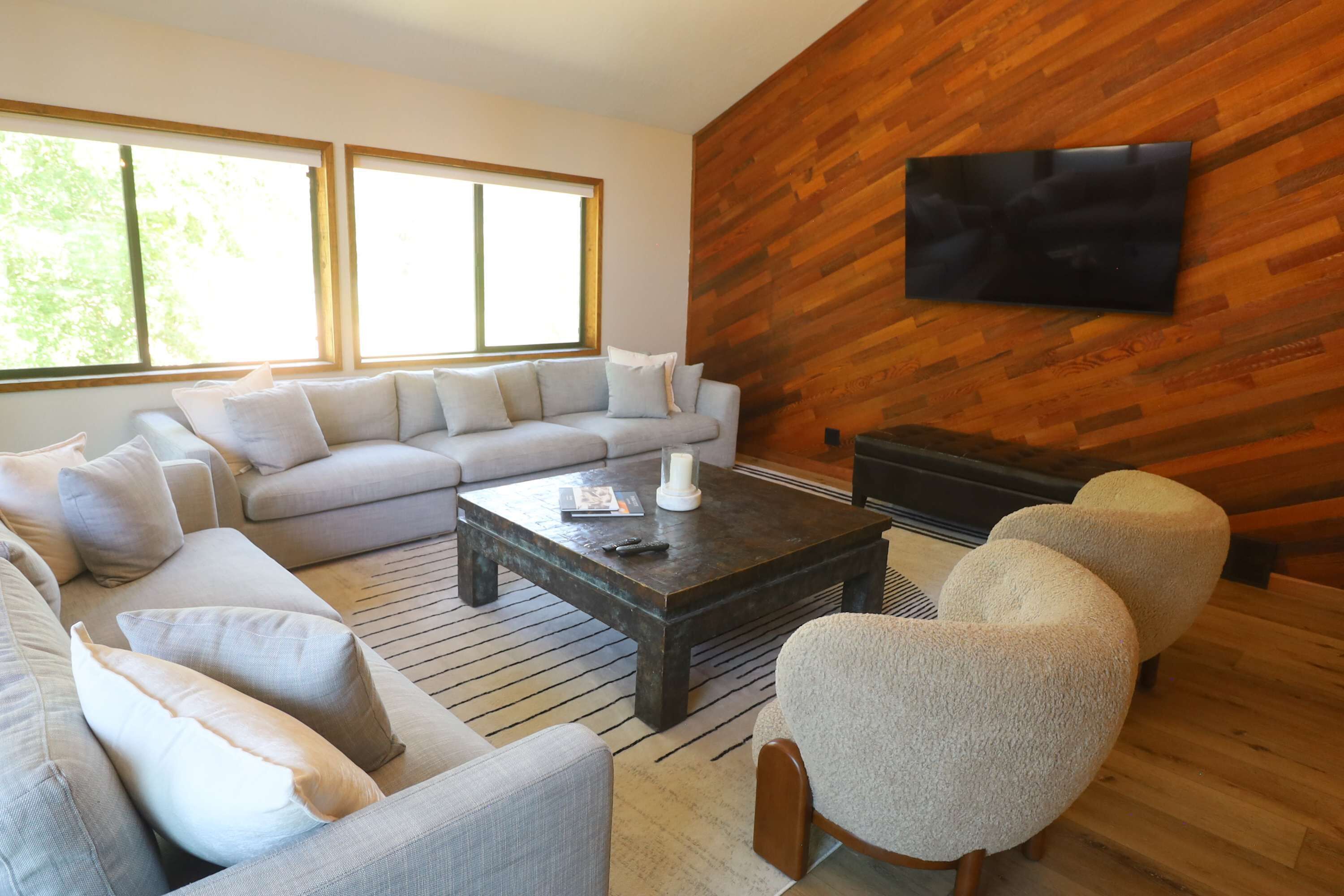A modern living room with a sectional sofa, a coffee table, and a fireplace.