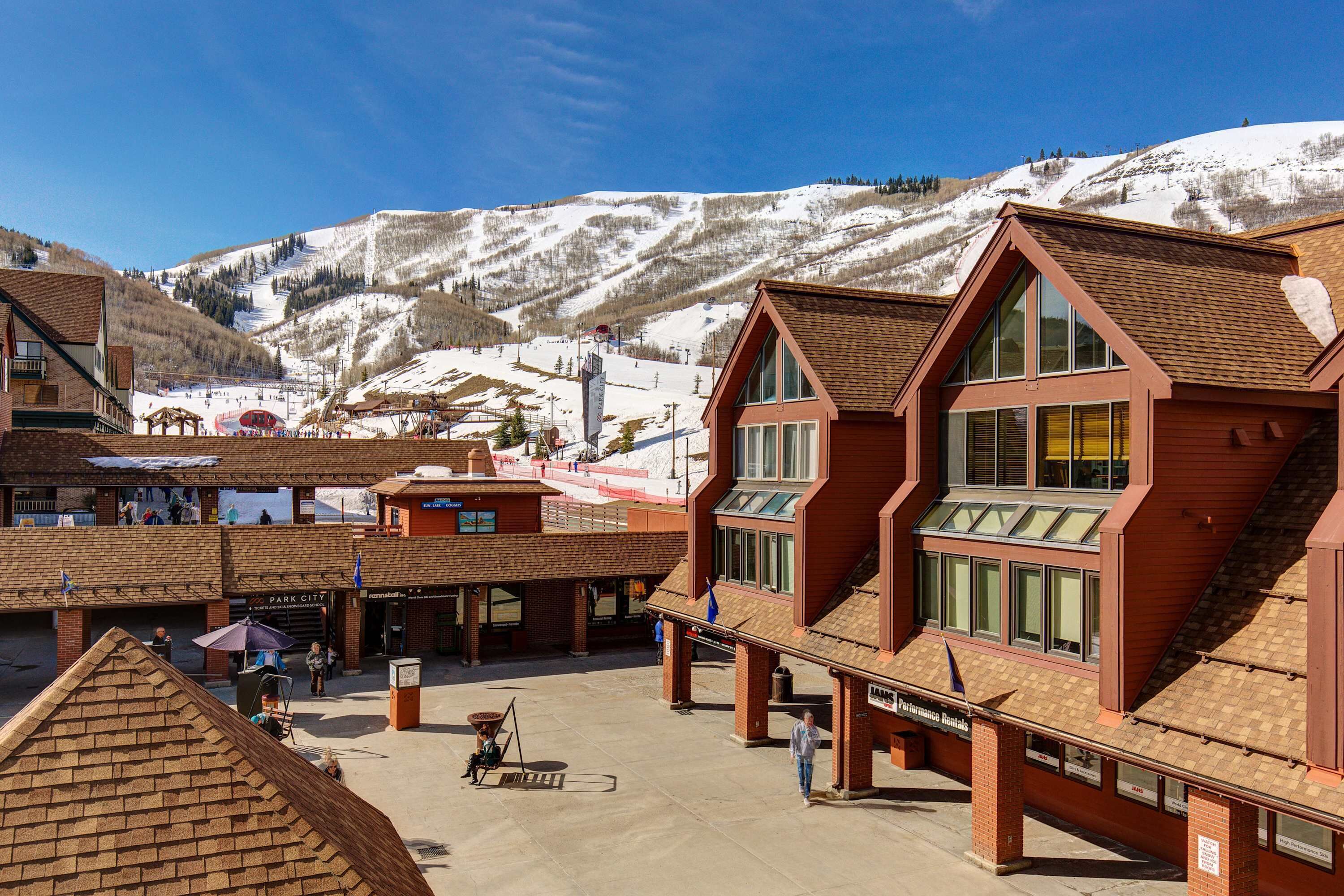 A building with a sloped roof and large windows, located in a snowy mountainous area.