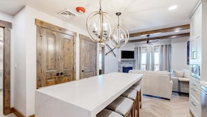 A modern kitchen with a large island, wooden doors, and pendant lighting. - Ski-in-ski-out condo - indoor & outdoor pools, sauna, hot tubs, game room, gym, W&D, AC (Park City)