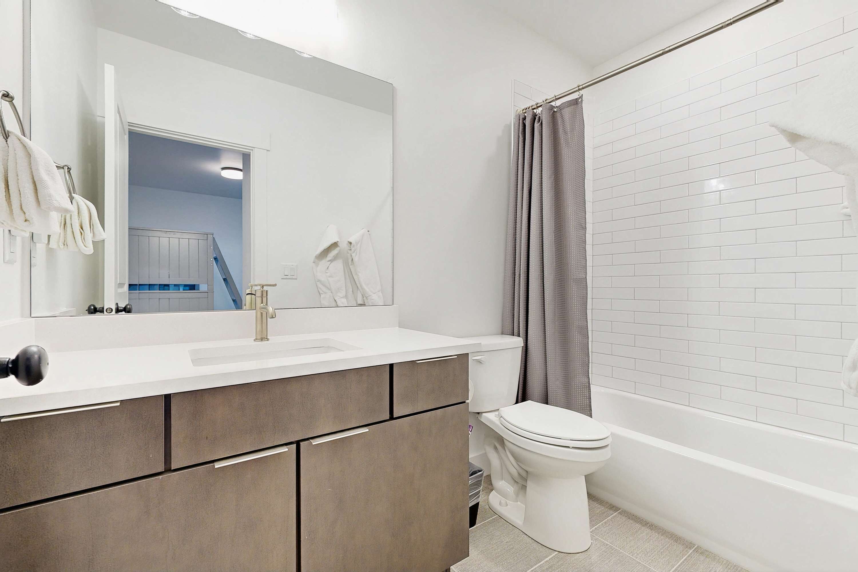 Un baño moderno con un lavabo blanco, un inodoro y una ducha.