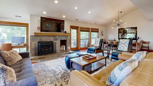 A spacious living room with a fireplace, comfortable seating, and large windows. - Walk to lifts & Main St condo with hot tub, heated garage, & mountain view (Park City)