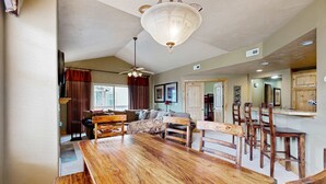 A spacious living area with a wooden dining table, a sofa, and a ceiling fan. - Spacious Redstone Home with Fireplace, Patio & Walk to Dining (Park City)