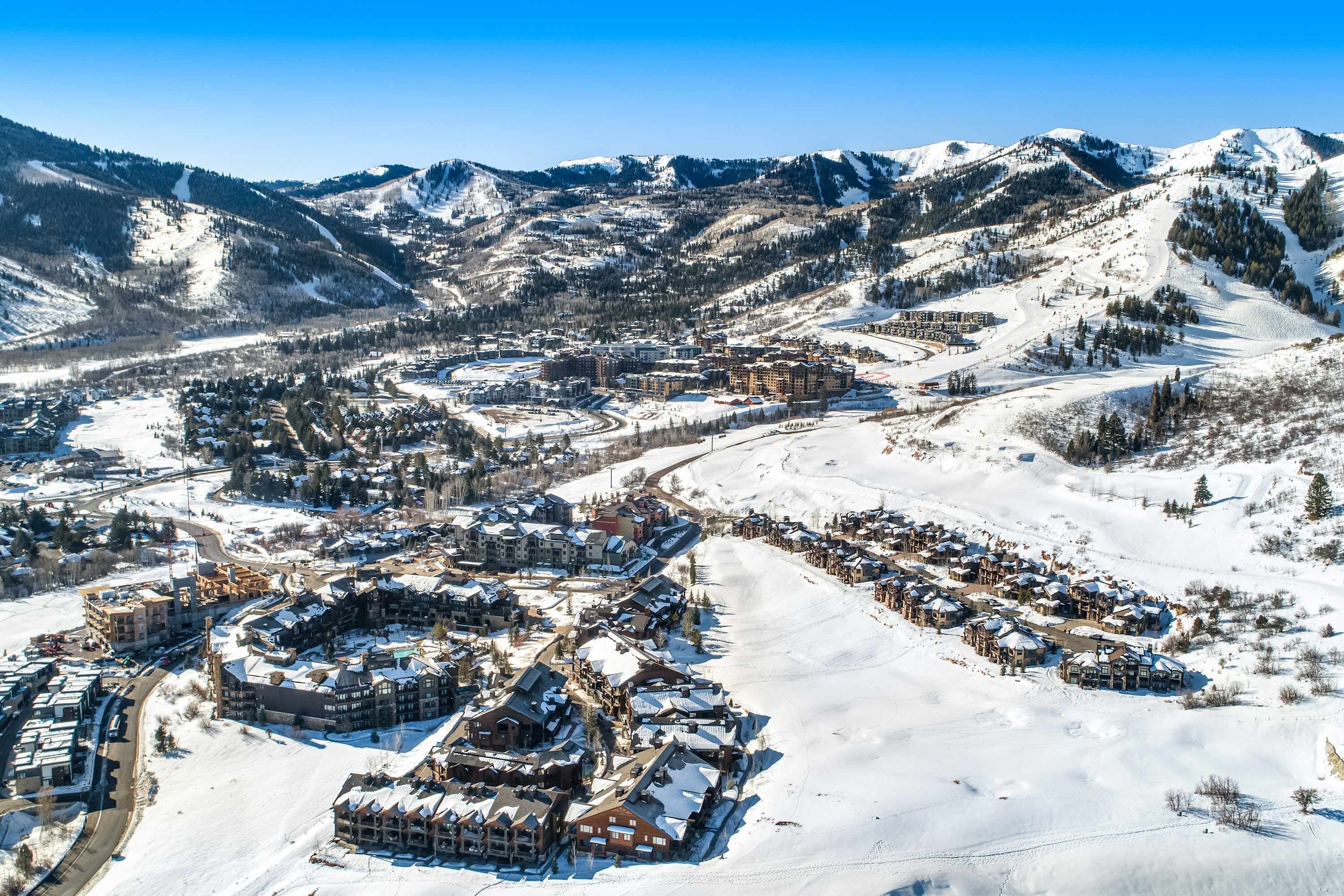 A snow-covered mountain town with buildings and ski slopes.