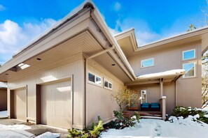 A modern two-story house with a garage, a covered porch, and a small garden area. - Conveniently located townhome with kitchen, kitchenette, balcony & fireplace (Bend)