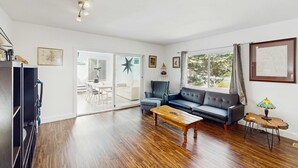 Un salón amplio con sofá, mesa de centro y mueble para la televisión.