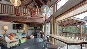 Ein rustikales Interieur mit einer Holztreppe, einer Couch, einem Tisch und einer Bar.
