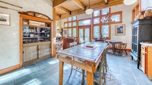 Une cuisine rustique avec des poutres en bois, de grandes fenêtres et un îlot central.