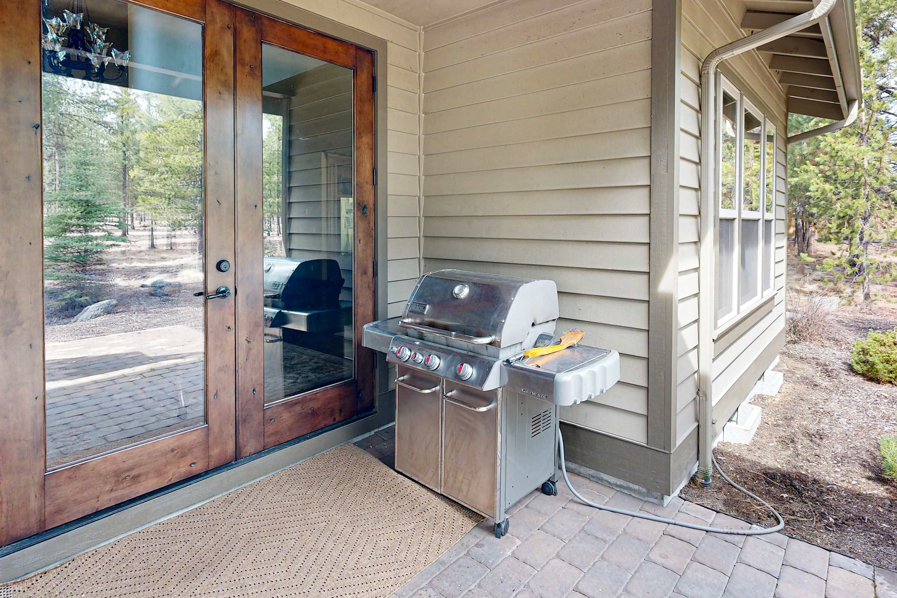Een barbecue en een houten deur met glaspanelen.