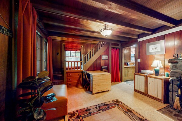 A wooden interior with a staircase, a small desk, and a lamp. - Unwind in nature's embrace at a 1925 cabin with hot tub & river views (Sandy)