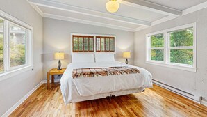 A bedroom with a bed, two bedside lamps, a window with blinds, and a ceiling fan. - Dog-friendly home & ocean views - near the beach (Manzanita)