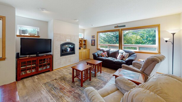 A living room with a fireplace, a television, a sofa, and a coffee table. - Dog-friendly 2-story duplex with gas fireplace, enclosed yard, gas grill & W/D (Manzanita)