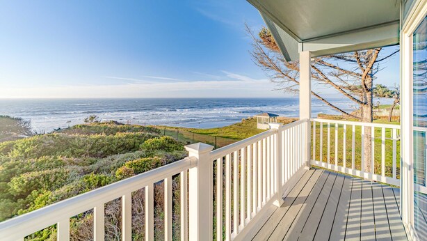A wooden deck with a white railing overlooking a coastal landscape. - Dog-friendly ocean view home with WiFi, remote work spaces, and washer&dryer (Gold Beach)