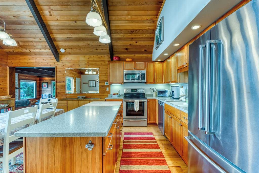 Een moderne keuken met houten kastjes, roestvrijstalen apparatuur en een centraal eiland.
