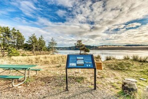A picnic area with a bench and a signboard. - Gorgeous riverfront house with entertainment - near Bay Street and the beach (Florence)