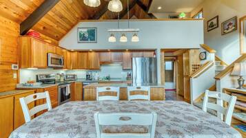 A kitchen with wooden cabinets, a microwave, and a dining area with a table and chairs.