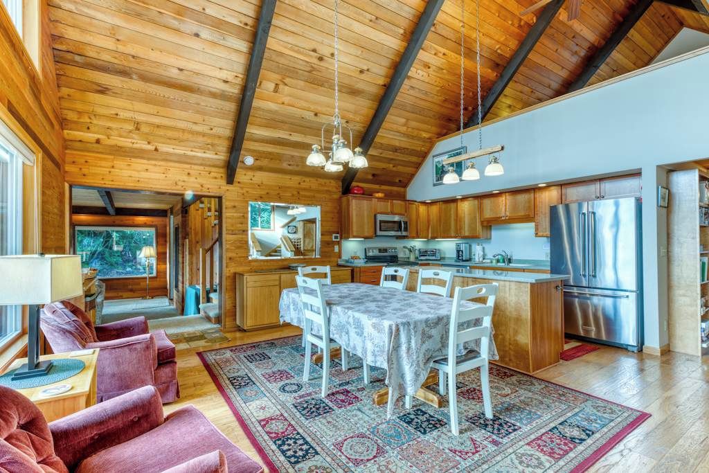 Un intérieur en bois comprenant un coin repas, une cuisine et un espace détente.