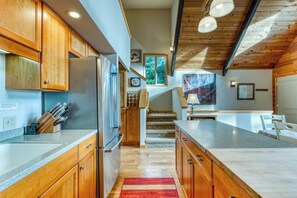 A kitchen with wooden cabinets, a refrigerator, and a countertop. - Gorgeous riverfront house with entertainment - near Bay Street and the beach (Florence)