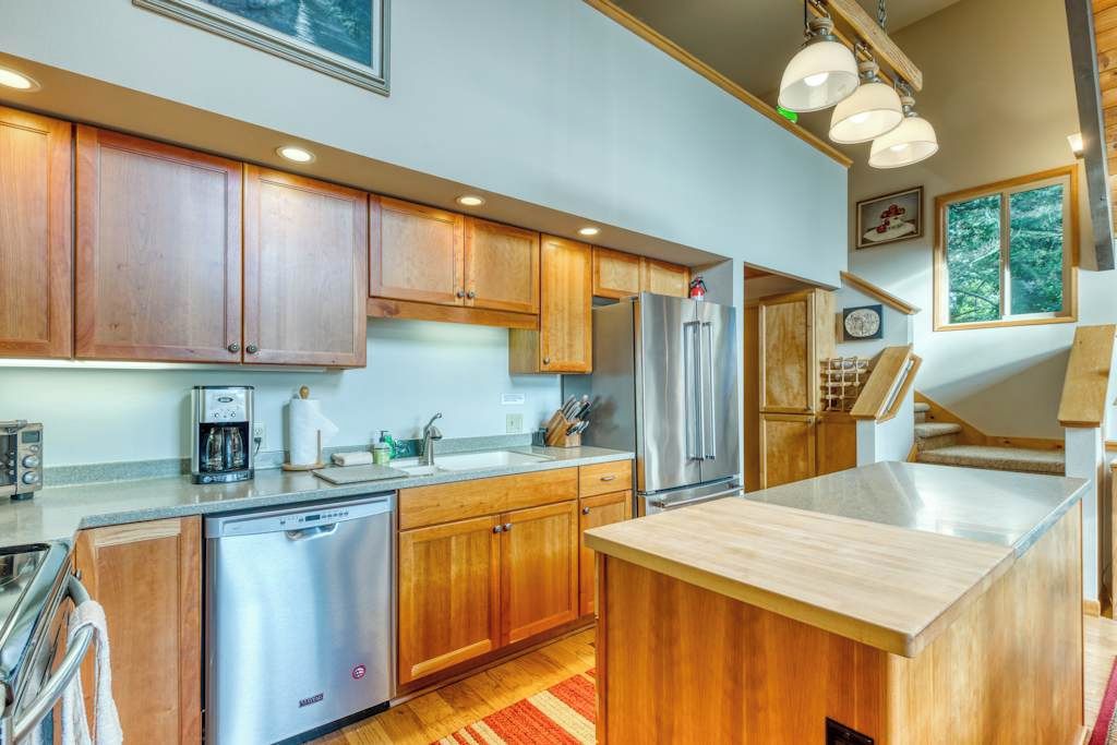 Une cuisine moderne avec des meubles en bois, des appareils électroménagers en acier inoxydable et un îlot central.