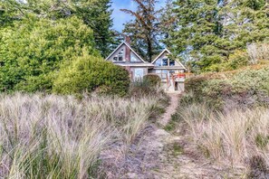 A house with a steep driveway leading to a wooden deck. - Gorgeous riverfront house with entertainment - near Bay Street and the beach (Florence)