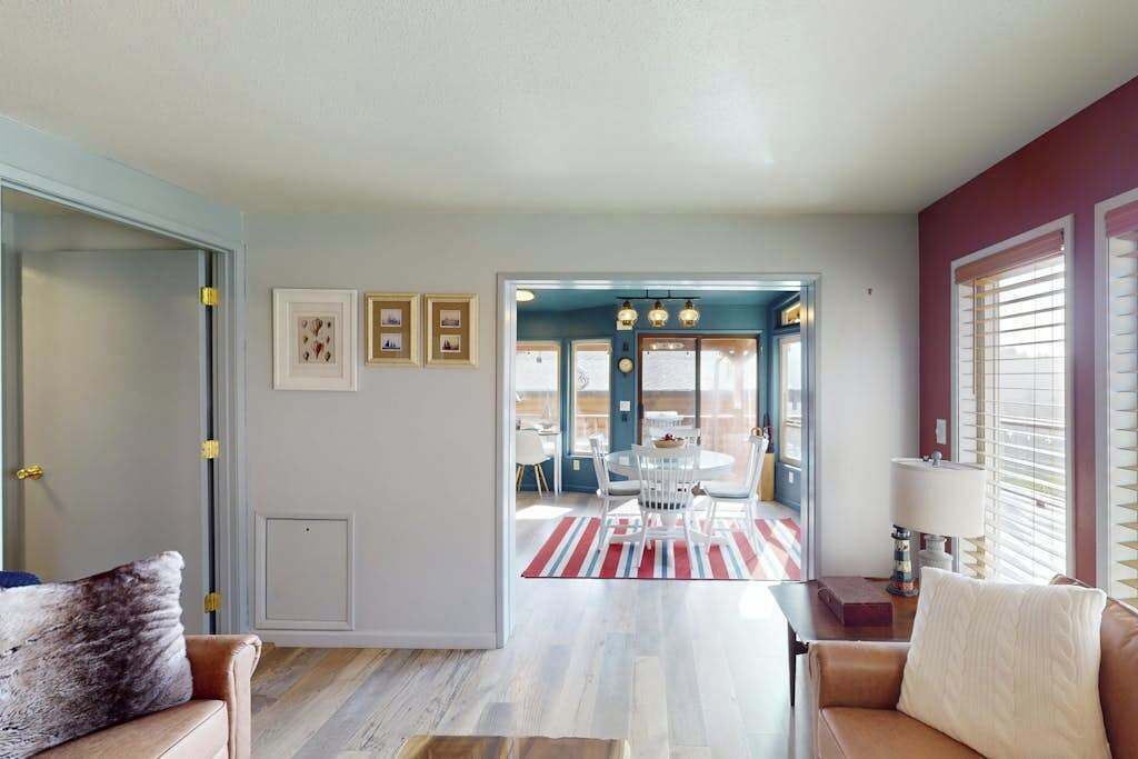 A living room with a sofa, a coffee table, and a dining area with a table and chairs.