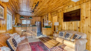 A wooden cabin interior with a living room, kitchen, and bar area. - Cozy pine interior home in the heart of Government Camp (Government Camp)
