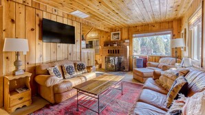 A wooden interior with a sofa, a coffee table, a TV, and a fireplace. - Cozy pine interior home in the heart of Government Camp (Government Camp)