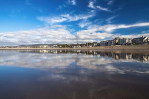 A waterfront property with a reflective water surface, a row of houses, and a clear sky. - Updated house with patio, great location near beach, dog-friendly (Seaside)