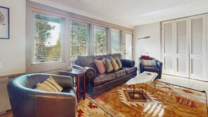 A living room with a leather sofa, a coffee table, and a patterned rug. - Dog-friendly ground-floor condo with pools, hot tubs, sauna, & fitness room (Bend)