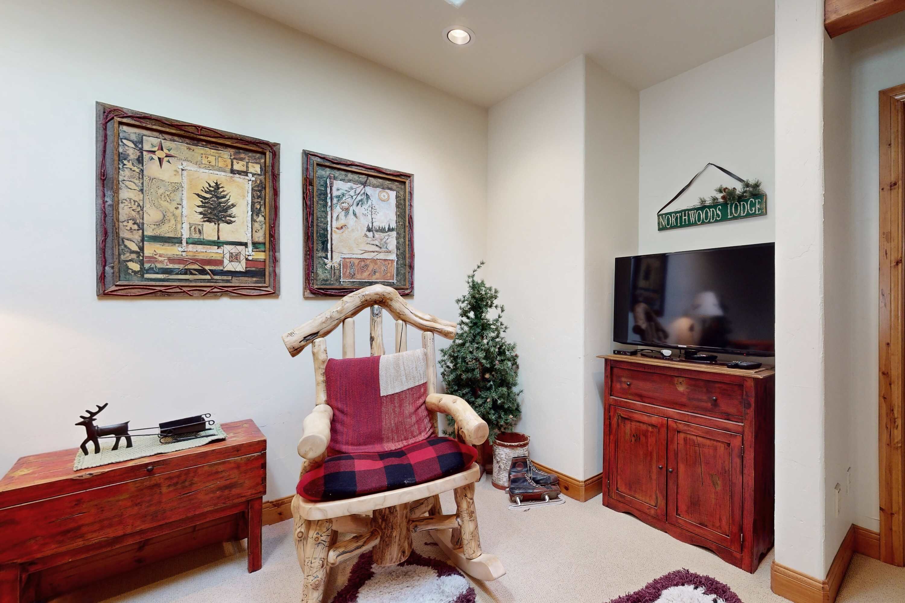 A cozy room with a wooden rocking chair, a television, and a Christmas tree.