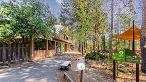 A nature center with a wooden building, a picnic table, and directional signs. - Comfortable Sunriver Home with Private Hot Tub and WiFi - Free SHARC Access (Sunriver)