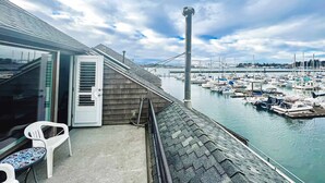 Ein Balkon mit Blick auf eine Marina, eine weiße Tür und ein kleiner Tisch.