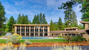 A building with a swimming pool, surrounded by trees and a fenced area. - Dog-friendly home next to South Meadow pool with fireplace & washer&dryer (Black Butte Ranch)