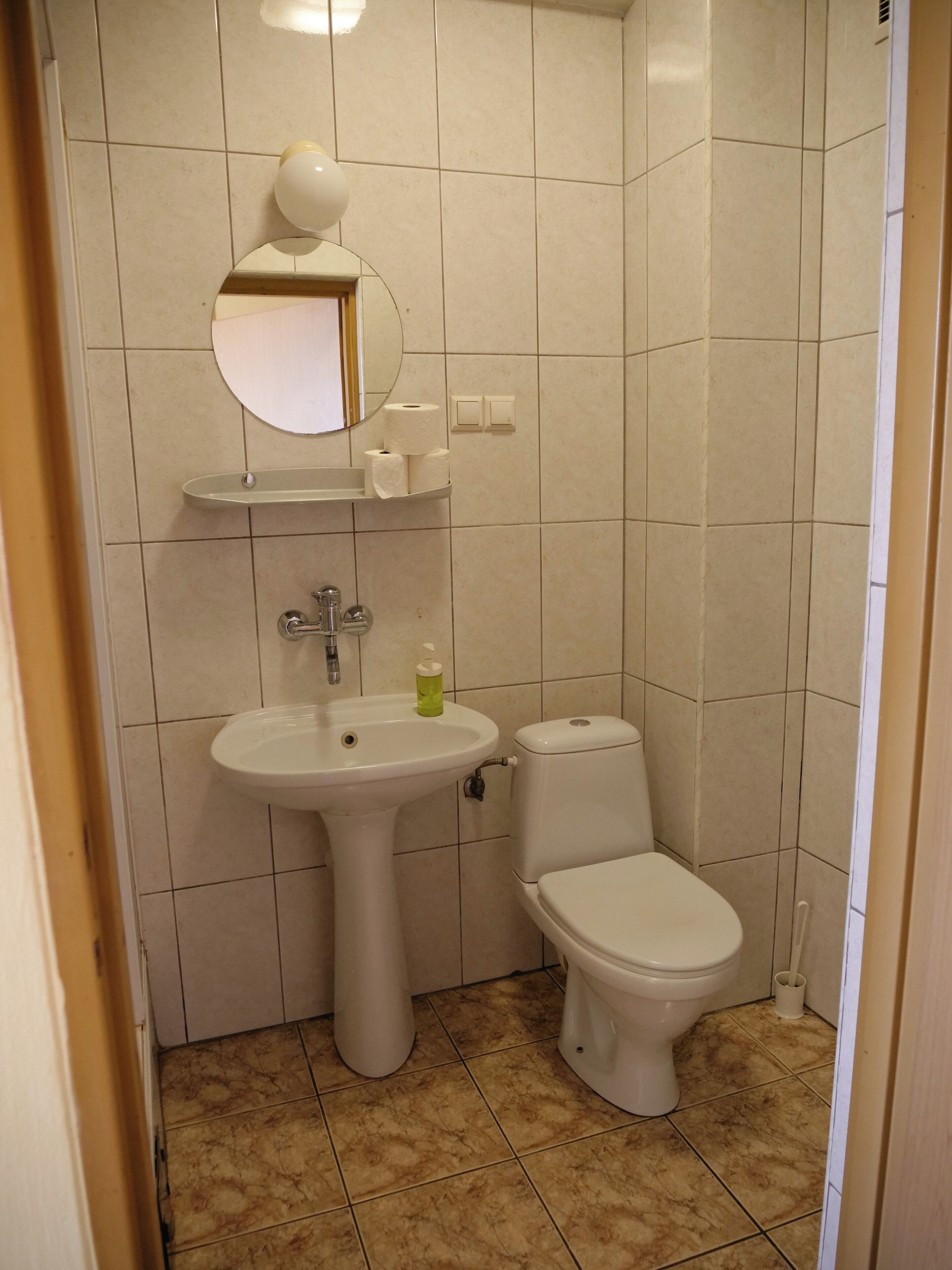 Ein Badezimmer mit Waschbecken, Toilette und Spiegel über dem Waschbecken.
