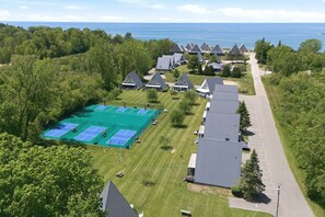 A residential area with houses, a tennis court, and a road. - Chalet #81: Nr Pool & Tennis + Resort Amenities (Stevensville)