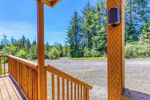 A wooden deck with a gravel path leading to a forested area. - Secluded & comfortable dog-friendly home with deck plus ATV & boat parking (North Bend)